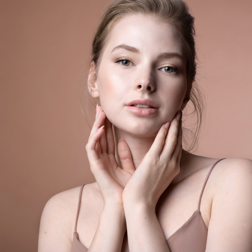 Pretty young caucasian female touching perfect flawless healthy skin. Girl enjoying result after beauty spa treatment, chemical peeling, cosmetics procedure. Cosmetology and dermatology advertising