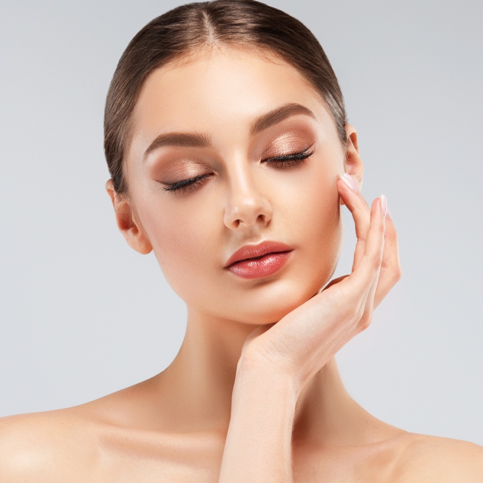 Beautiful young woman with clean fresh skin on face . Girl facial treatment . Cosmetology , beauty and spa .